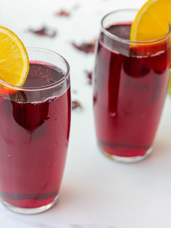 Floral, naturally deep red, and irresistibly refreshing. This agua de Jamaica recipe is made with dried hibiscus flowers, sugar, and warm spices. Classic and easy.